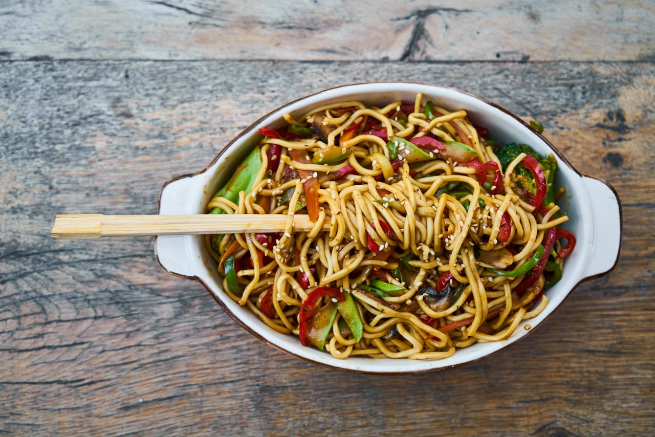 team-01 Tasty stir-fried noodles with fresh vegetables and sesame seeds, perfect for a healthy meal.