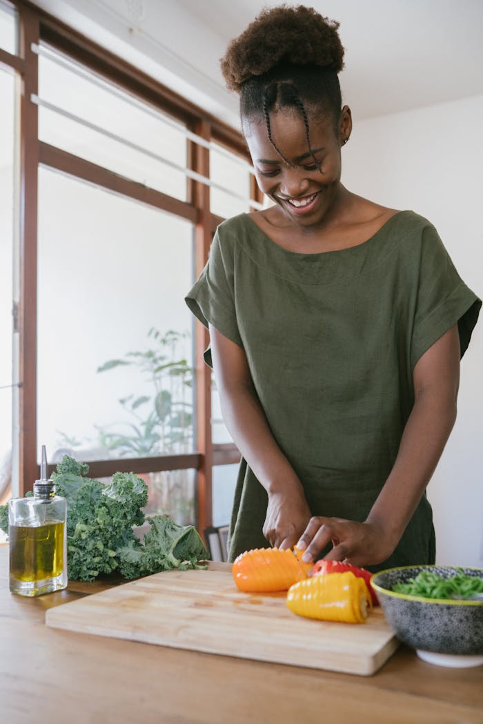 team-04 Smiling woman in kitchen slicing bell peppers, promoting healthy eating and joy in food preparation.