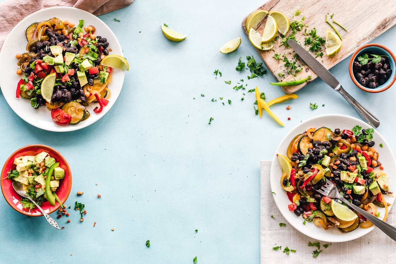 embark Colorful Mexican salad with avocado, black beans, and lime on a light blue surface.