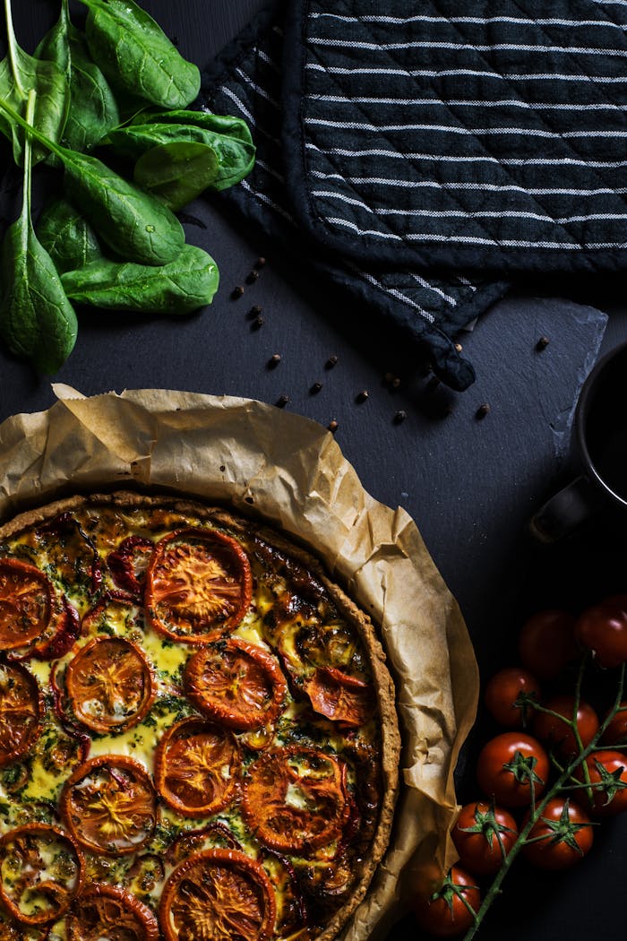 team-02 A delicious homemade tomato quiche with fresh spinach, ready to serve, perfect for dinner.